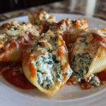 Close-up of baked Creamy Spinach and Ricotta Stuffed Shells topped with melted cheese and marinara sauce.
