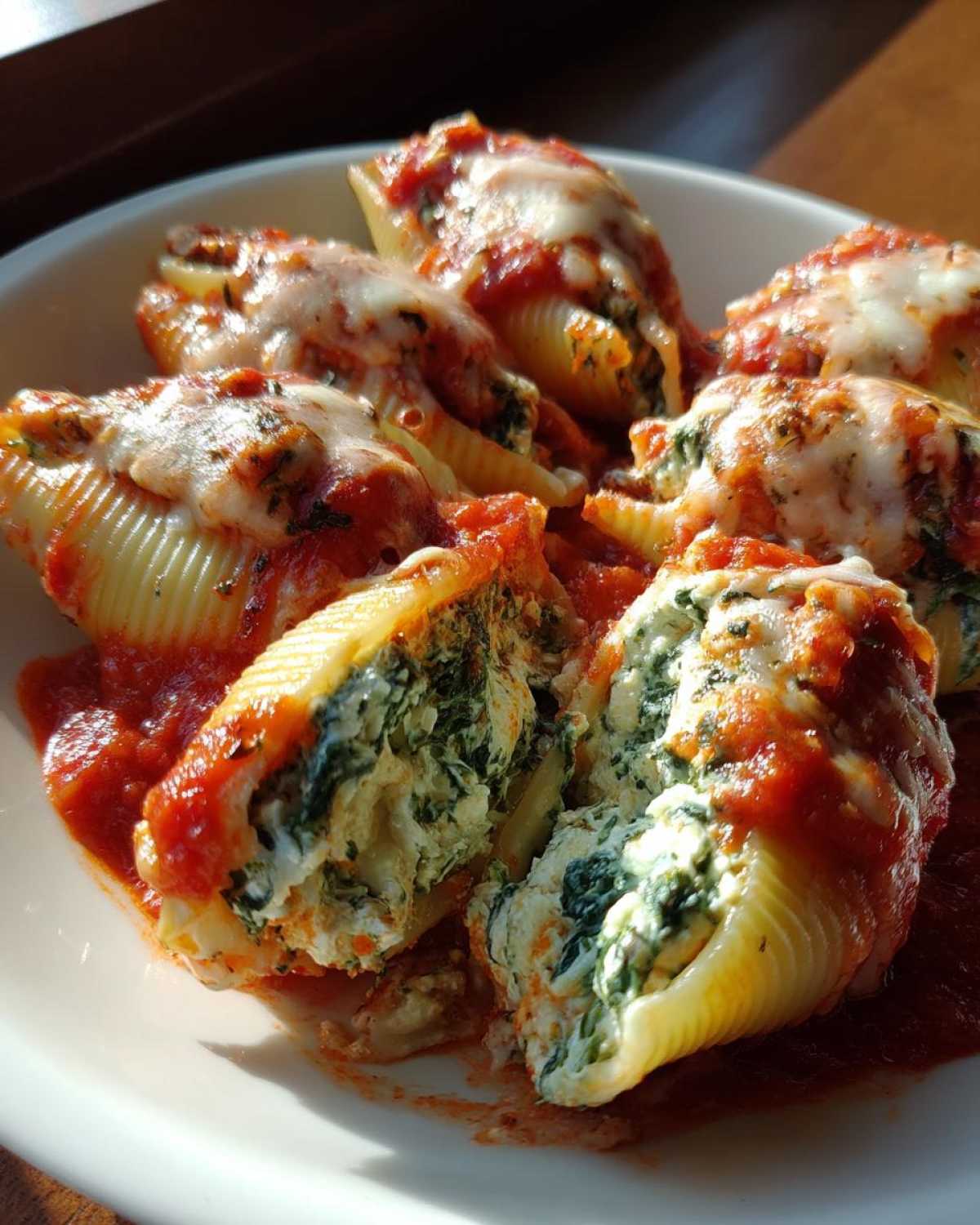Close-up of baked Creamy Spinach and Ricotta Stuffed Shells covered in marinara sauce and melted mozzarella.