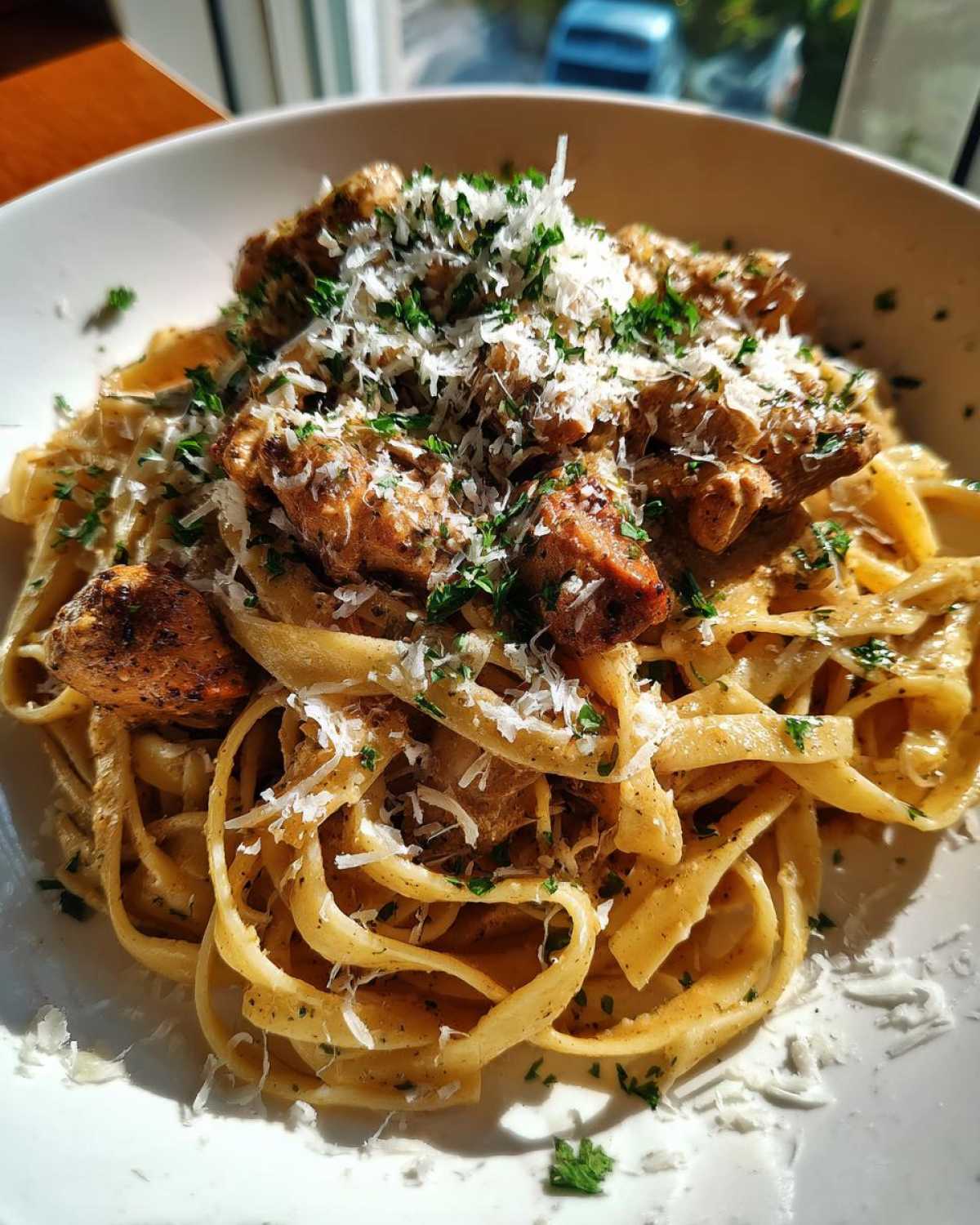 A close-up of creamy Garlic Butter Chicken Pasta with Parmesan, topped with fresh parsley.