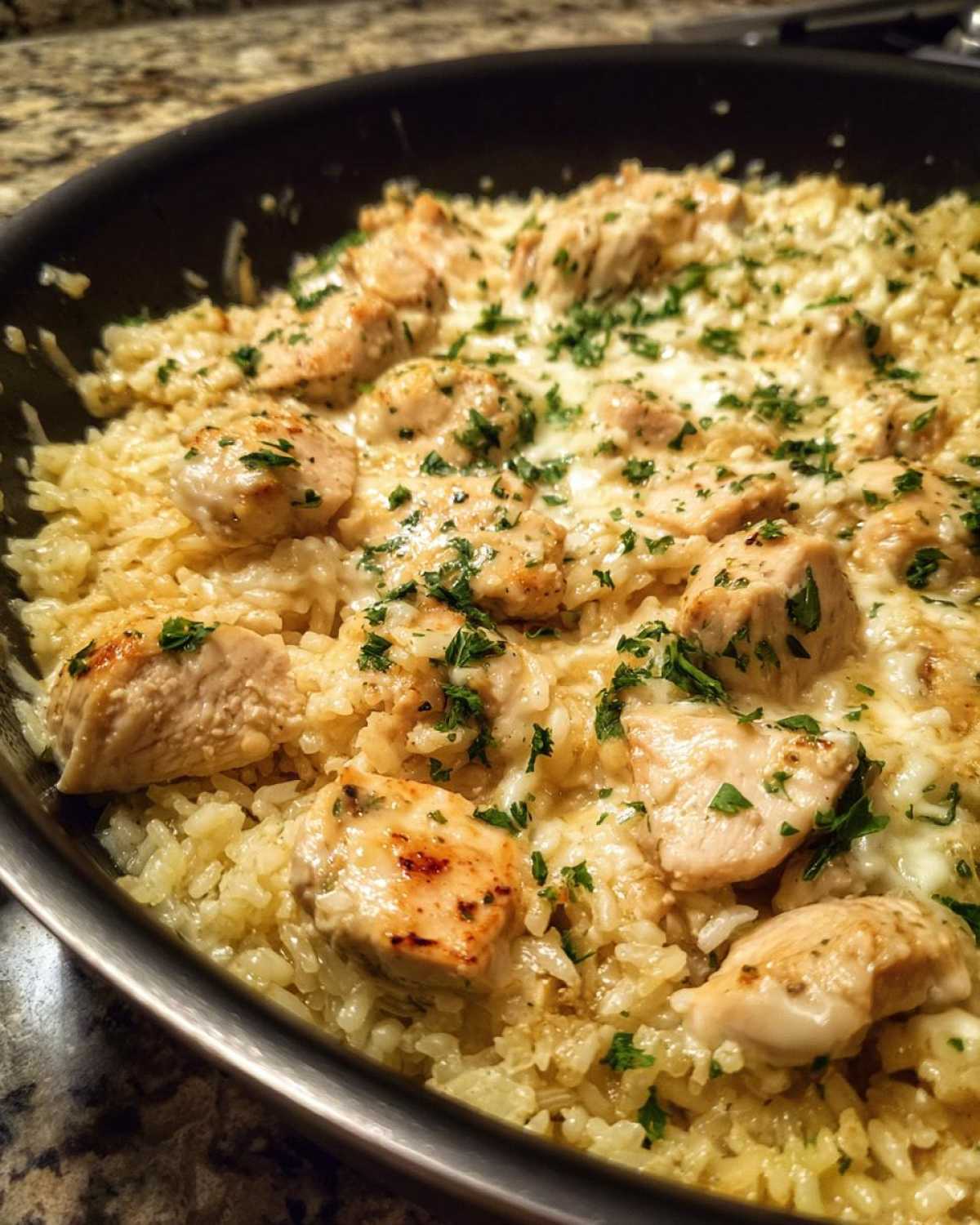 Close-up of Garlic Butter Rice with Chicken Skillet, featuring creamy rice, seared chicken pieces, and fresh parsley garnish.