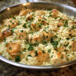 Close-up of Garlic Butter Rice with Chicken Skillet topped with parsley and parmesan cheese in a stainless steel pan.