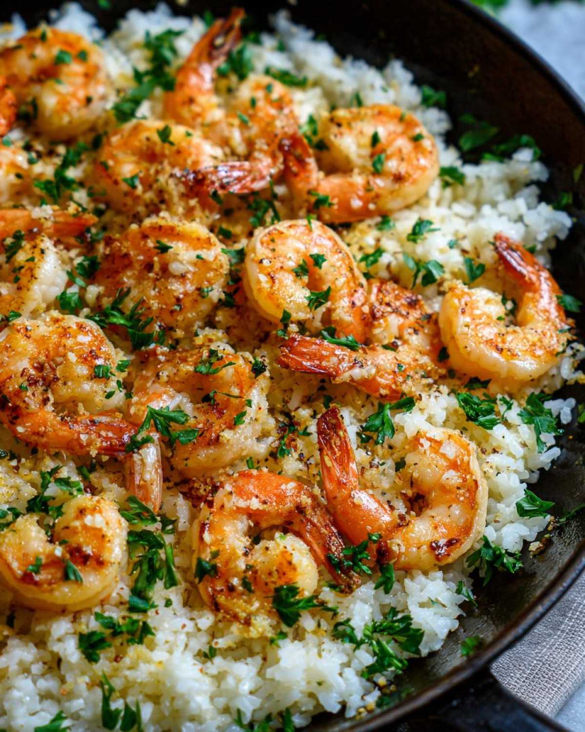 Close-up of Garlic Butter Shrimp and Rice Easy Recipe, featuring plump shrimp over white rice, garnished with parsley.