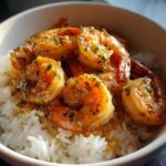 Close-up of a white bowl filled with fluffy white rice topped with succulent Garlic Butter Shrimp Bowl with Rice.