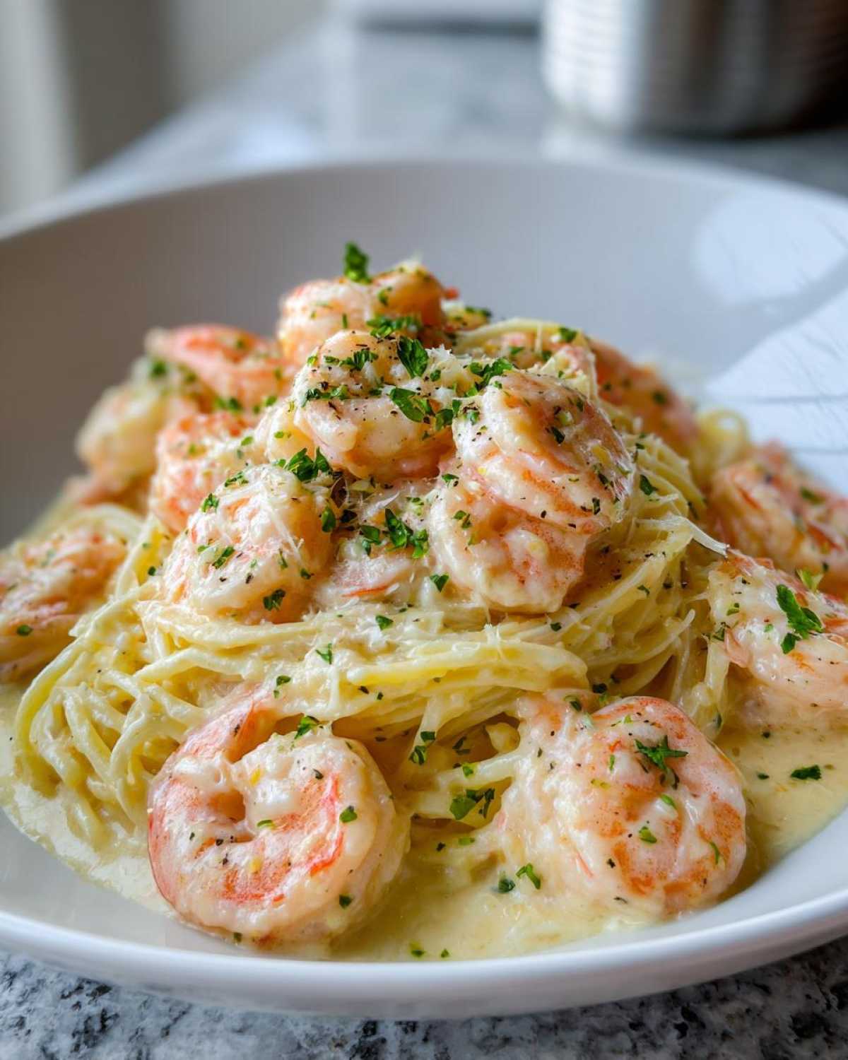 Close-up of Garlic Butter Shrimp with Creamy Parmesan Sauce served over linguine pasta, garnished with parsley.