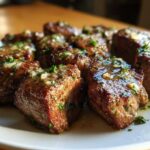 Close-up of several Garlic Butter Steak Bites, perfectly seared and glistening with garlic butter sauce and parsley.