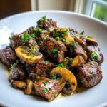 Close-up of tender Garlic Butter Steak Bites with sautéed mushrooms, glistening in sauce and topped with parsley.