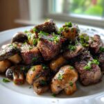 A pile of juicy Garlic Butter Steak Bites mixed with sautéed mushrooms, garnished with fresh parsley.