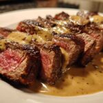 Perfectly cooked, medium-rare Garlic Butter Steak sliced and drizzled with a rich, creamy sauce.