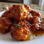 Close-up of glistening Honey Butter Chicken Skillet pieces coated in a rich glaze and sprinkled with herbs.