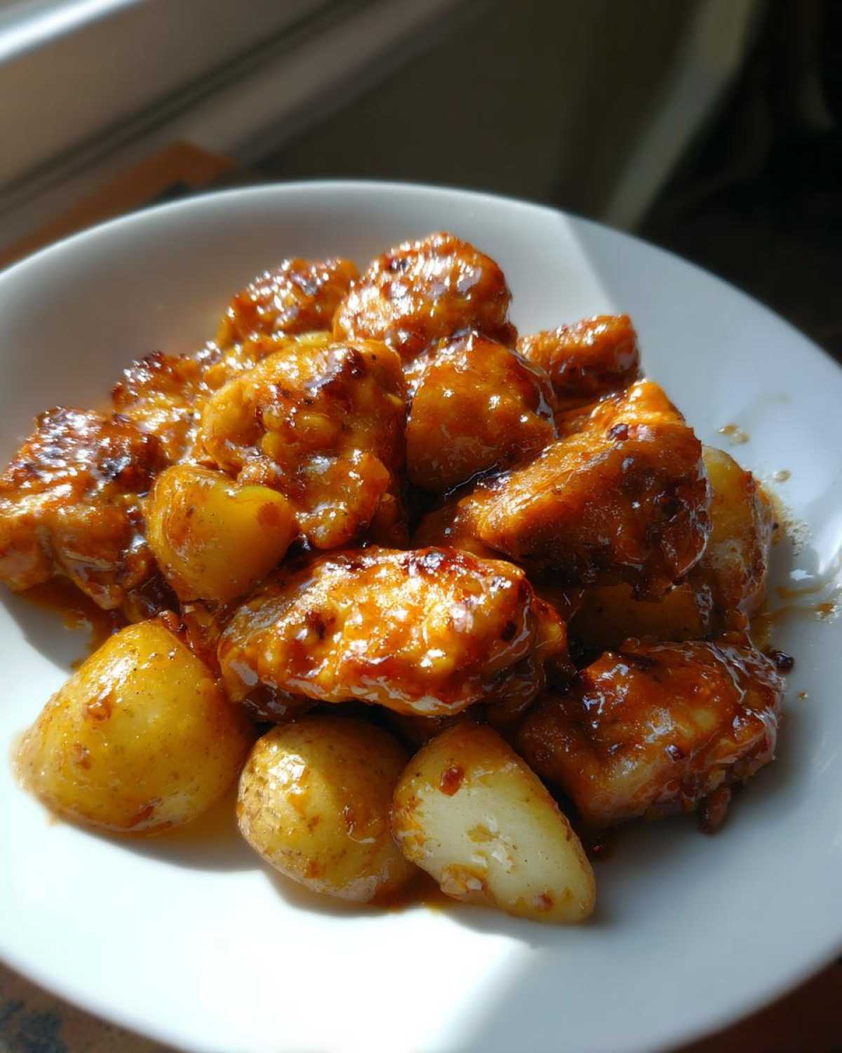 Close-up of glossy, glazed chicken pieces and small roasted potatoes from the Honey Mustard Chicken Skillet with Potatoes.