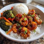 Close-up of a Honey Sriracha Shrimp Bowl with glazed shrimp, white rice, and roasted vegetables.