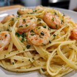 Close-up of a plate featuring Lemon Butter Shrimp Pasta Ready in 20 Minutes, topped with plump shrimp and fresh parsley.