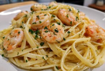 Close-up of a plate featuring Lemon Butter Shrimp Pasta Ready in 20 Minutes, topped with plump shrimp and fresh parsley.
