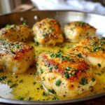 Five golden-brown pieces of Lemon Garlic Butter Chicken Easy Skillet simmering in rich lemon garlic butter sauce.