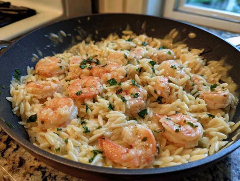 Close-up of creamy Lemon Garlic Shrimp Orzo one pan dinner garnished with fresh parsley in a skillet.