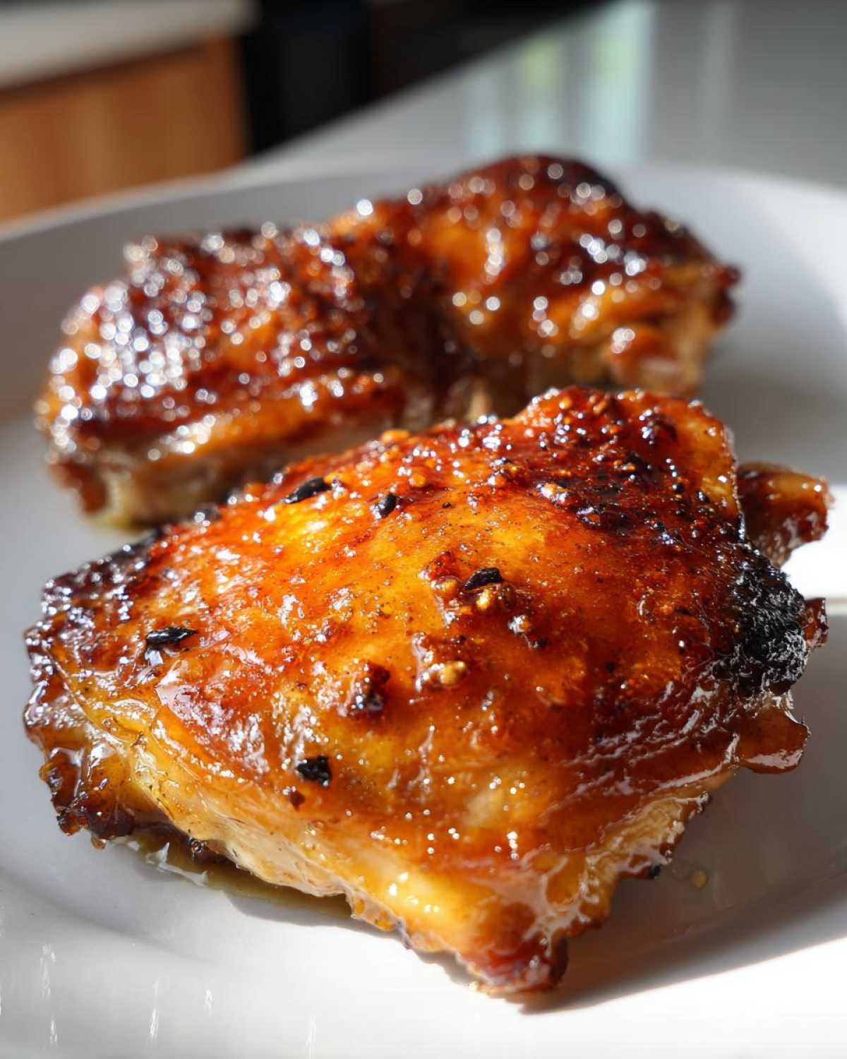 Two pieces of perfectly cooked Sticky Honey Soy Chicken Thighs with a glossy, caramelized glaze.