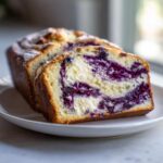 Close-up of a sliced Blueberry Cream Cheese Bread Loaf showing rich blueberry swirls and cream cheese filling.