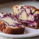Close-up of two slices of Blueberry Cream Cheese Bread Loaf showing the marbled purple blueberry swirl inside.