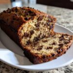 Close-up of a sliced loaf of One-Bowl Banana Bread with Chocolate Chips, showing moist texture and melted chips.