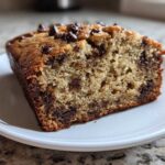 Close-up of a moist slice of One-Bowl Banana Bread with Chocolate Chips showing the crumb texture and melted chips.