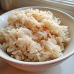 Close-up of creamy Parmesan Risotto served in a white bowl, showing the texture of the rice.