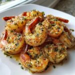 A close-up of perfectly cooked Air Fryer Garlic Parmesan Shrimp seasoned with visible garlic and parsley.