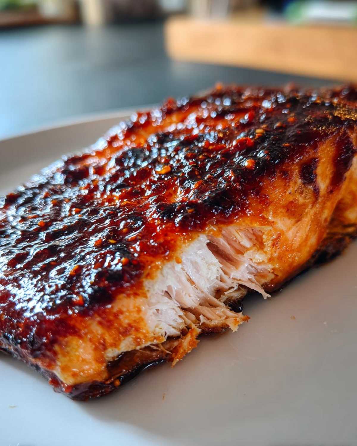 Close-up of flaky, cooked salmon fillet topped with a thick, glossy Gochujang Honey Glazed Salmon sauce.