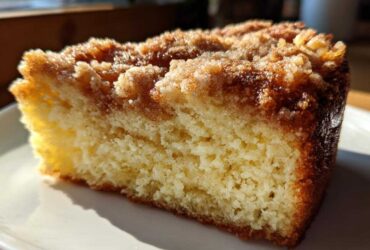Close-up of a moist slice of Lemon Coffee Cake with Lemon Crumb Topping, showing the tender crumb and sugary topping.